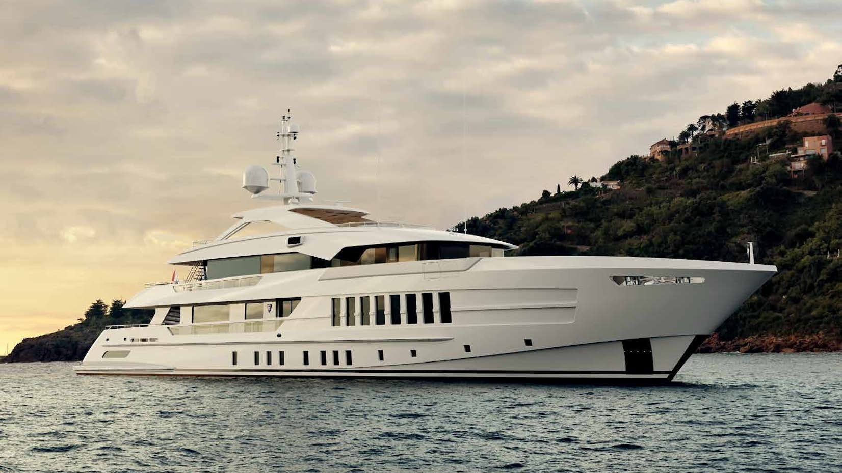 Heesen 55 Steel yacht anchored near a lush coastline, featured by Northrop & Johnson.