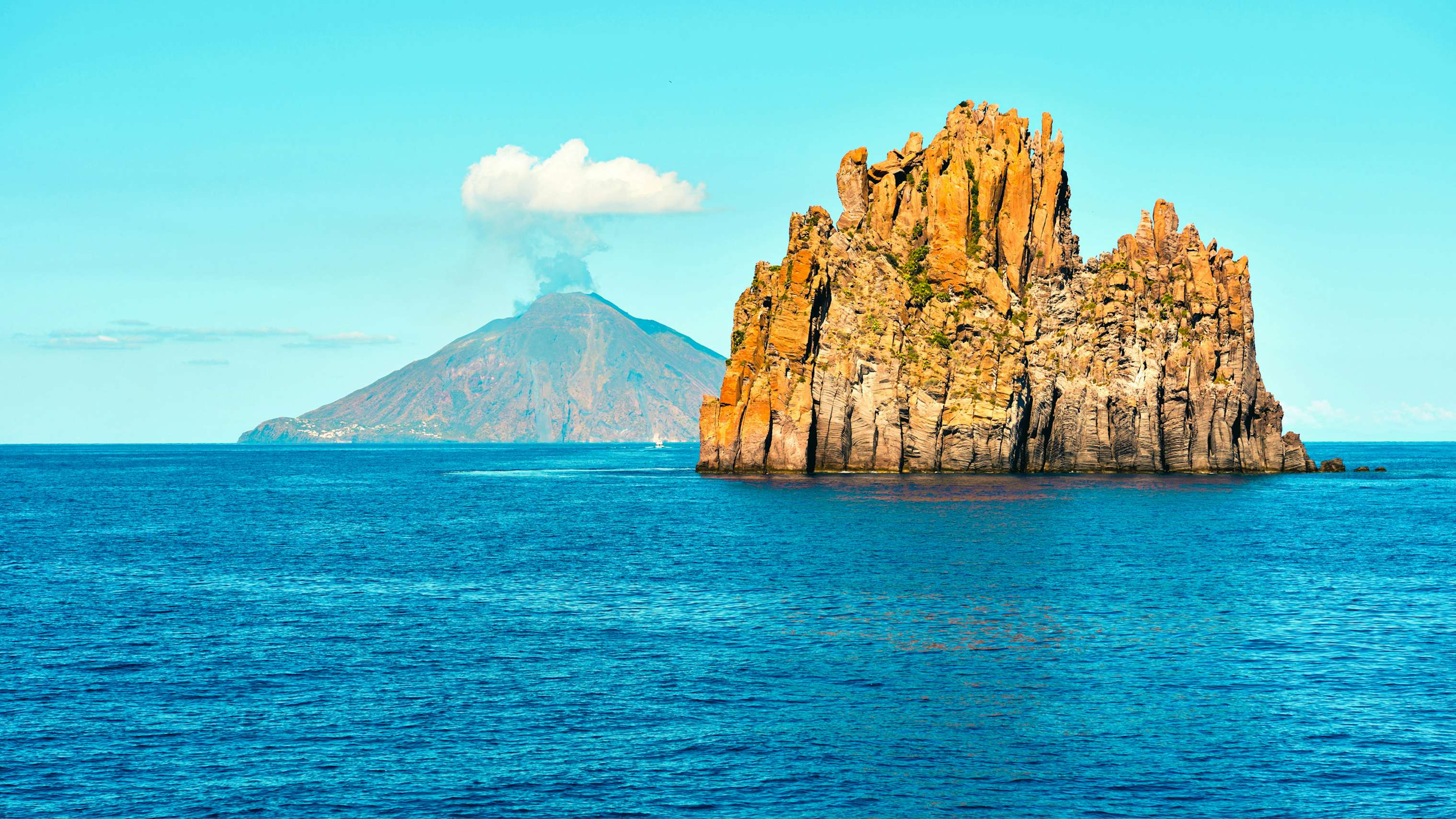 A unique rocky islet off the coast of Sicily, viewed from a yacht chartered with N&J, showcasing potential exploration sites.