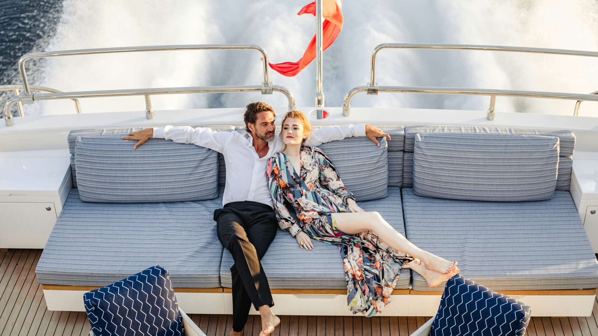 Young couple relaxing on the back of a yacht deck