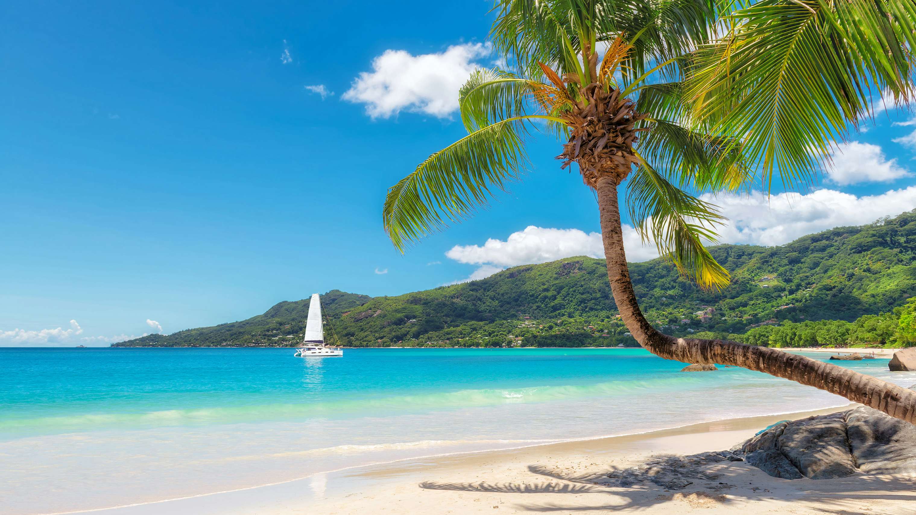 Seychelle Yacht Charter - Mahe largest island of the Seychelles picturesque ocean with a single sailing yacht rental in background